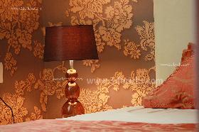 Wall paper lit by the lamp giving it orange hues